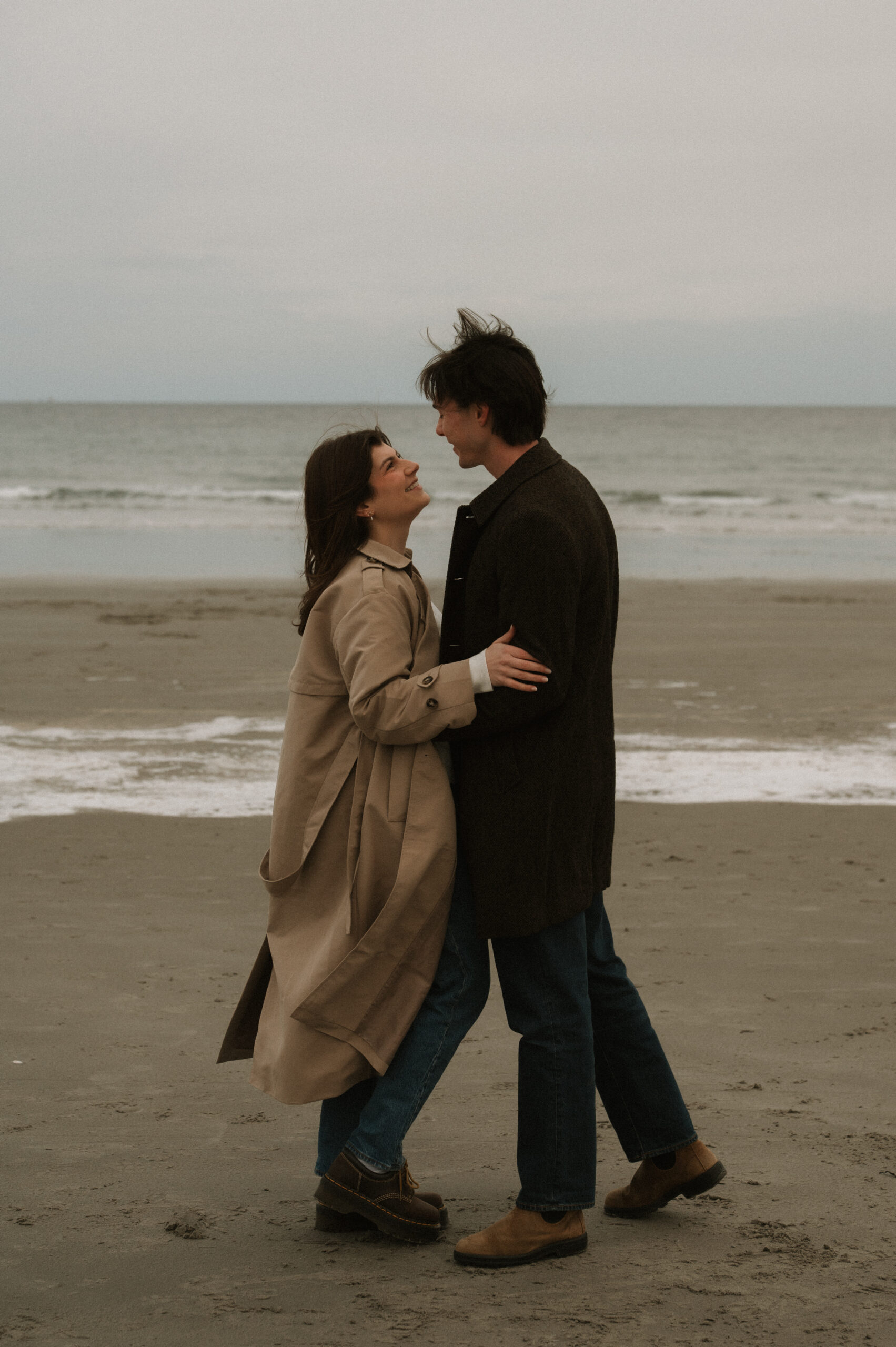 Moody coastal engagement session on the New Hampshire seacoast with overcast skies and ocean views
