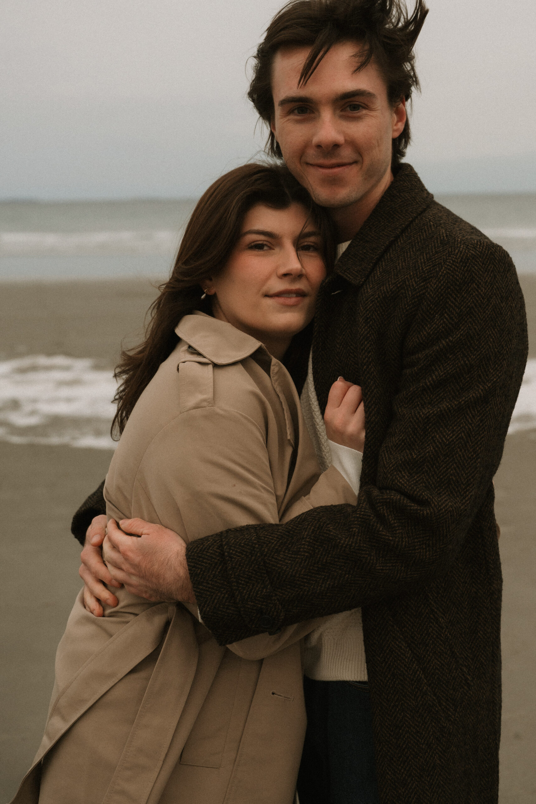 Moody seaside engagement photos in New Hampshire with natural movement and emotion