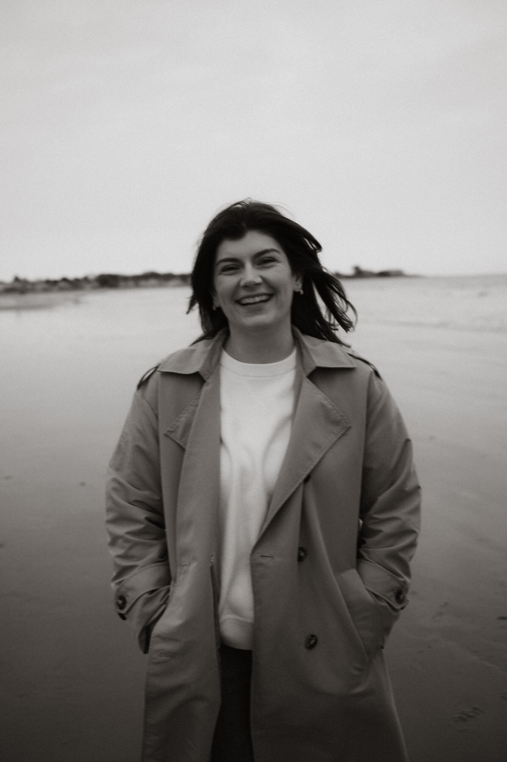 Cinematic New England coastal engagement session with dramatic skies and ocean horizons