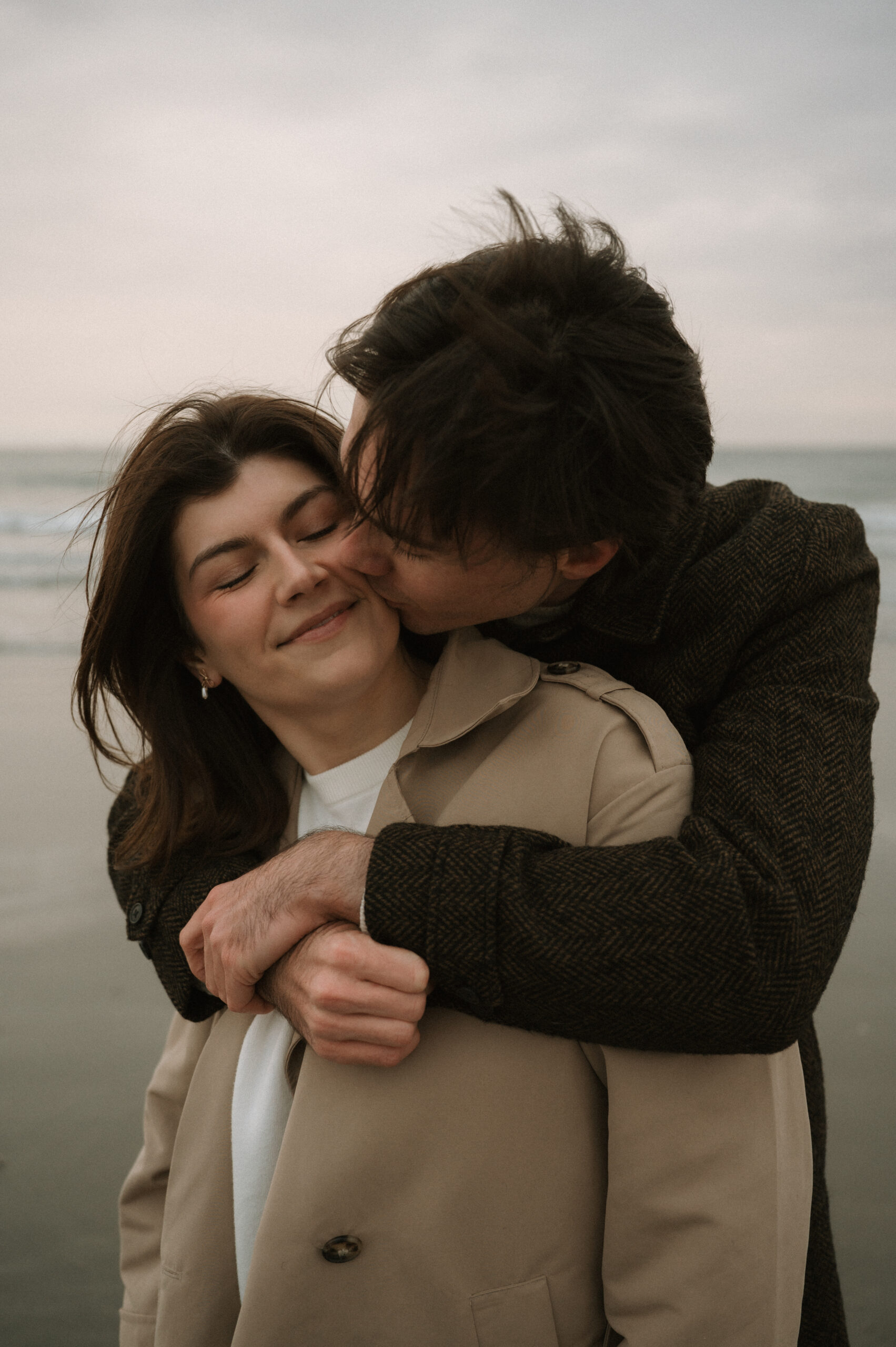 Cinematic New England coastal engagement session with dramatic skies and ocean horizons